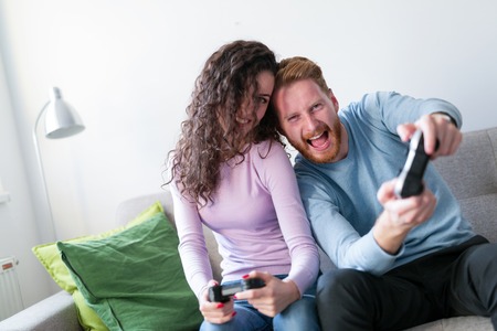 Young couple having fun playing video gamesの写真素材