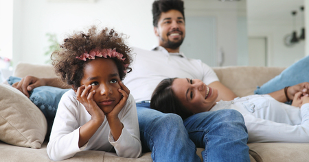 Happy family watching television at their homeの写真素材