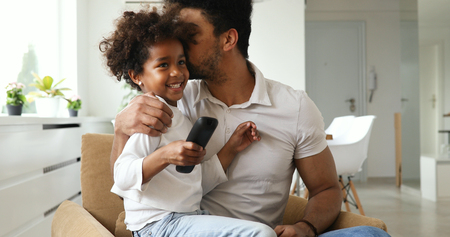 happy father and daughter and watching tv at homeの写真素材