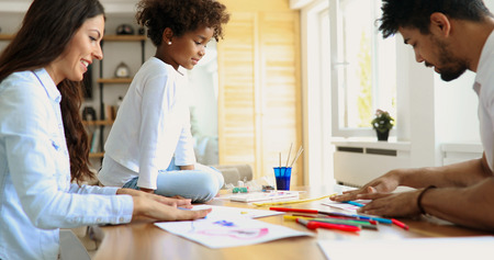 Mother and father drawing together with their child