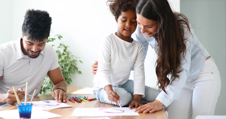 Mother and father drawing together with their child