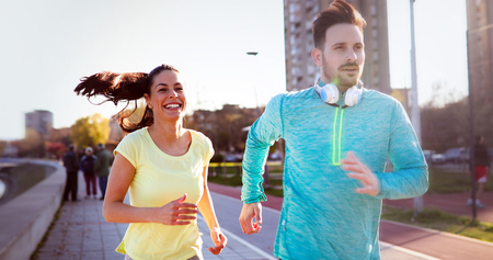 Young attractive couple running outside on sunny dayの写真素材