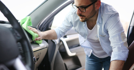 Person cleaning car with microfiber clot and maintaining shineの写真素材
