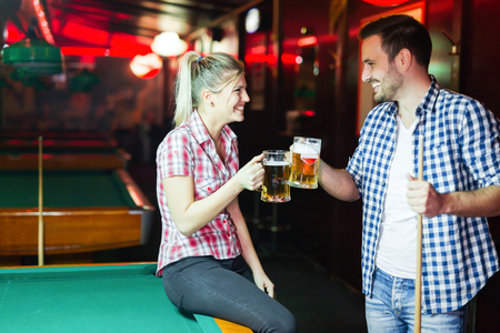 Couple drinking beer playing snooker on dateの写真素材