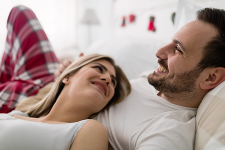 Young attractive couple having romantic time in bedの写真素材