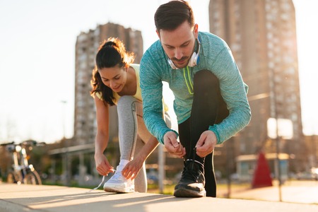 Runners tying running shoes and getting ready to runの写真素材