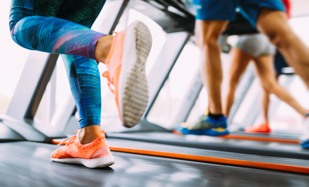 Group of friends exercising on treadmill machineの写真素材