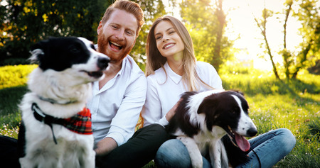 Romantic happy couple in love enjoying their time with pets in nature