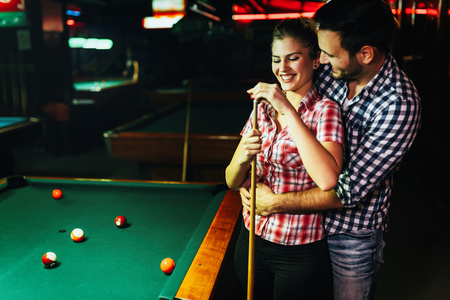 Young attractive couple on date in snooker clubの写真素材