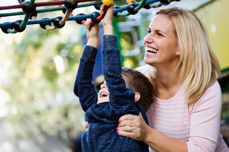 Mother and son having fun while playing in the parkの写真素材