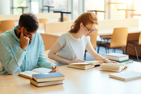 Young students studying in libraryの写真素材