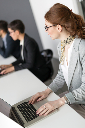 Young employee working on computer during working day in officeの写真素材