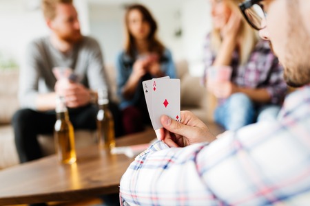 Group of friends having fun while playing cardsの写真素材