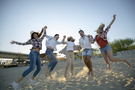 Happy group of young people having fun at beachの写真素材