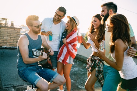 Group of happy friends having party on rooftop