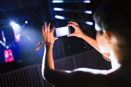 Picture of woman recording music performance at festivalの写真素材