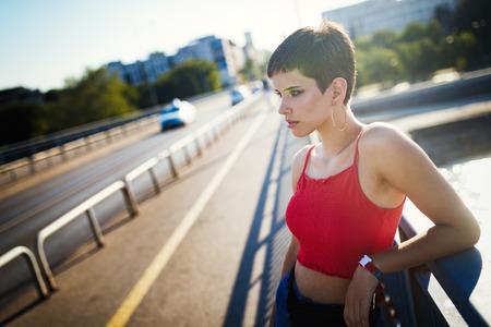 Portrait of young woman relaxing on bridgeの写真素材