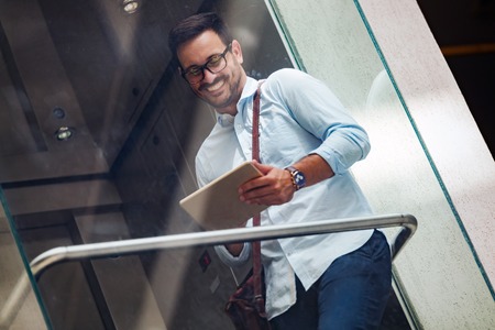 Portrait of businessman in glasses holding tabletの写真素材