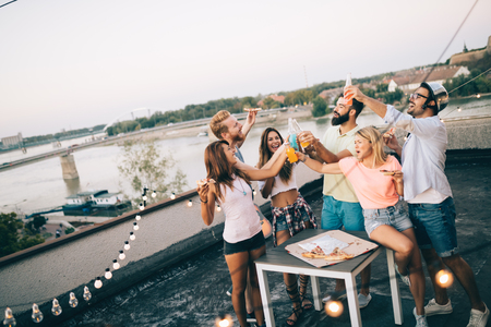 Group of happy friends having party on rooftopの写真素材