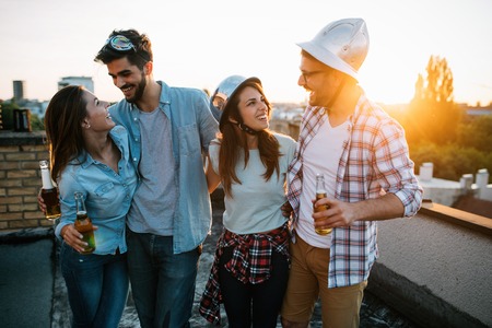 Group of happy friends having party on rooftopの写真素材