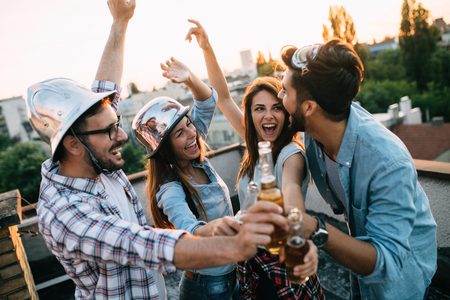Group of happy friends having party on rooftopの写真素材