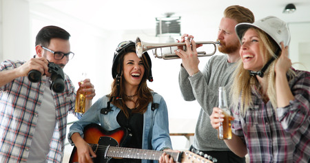 Happy young friends having fun and partying to music