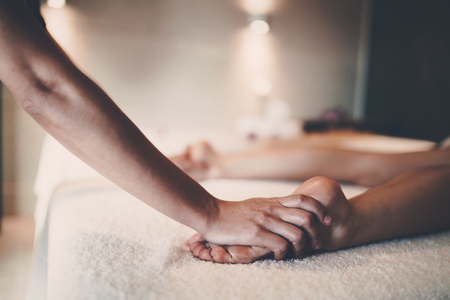 Masseur massaging masseuse during therapeutic tretmentの写真素材