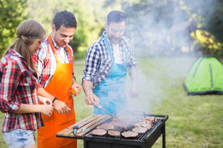 Happy people having camping and having bbq partyの写真素材