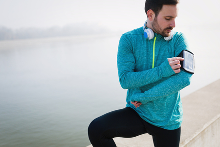 Determined sportsman fitness exercising by jogging outdoorの写真素材