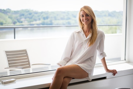 Young beautiful girl with long brown hair in white men shirtの写真素材