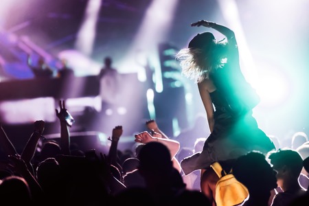 Cheering crowd with hands in air at music festivalの写真素材