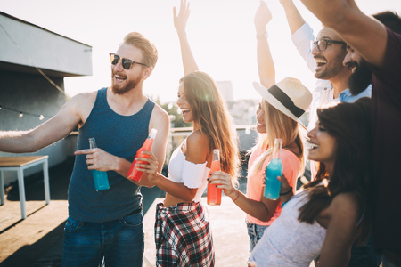 Group of happy friends having party on rooftopの写真素材