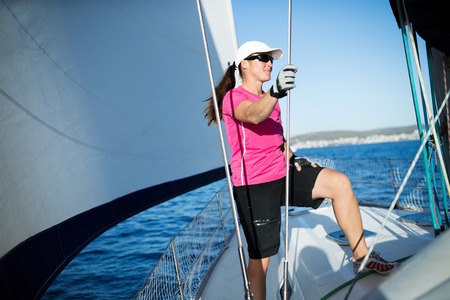 Happy strong woman sailing with her boat