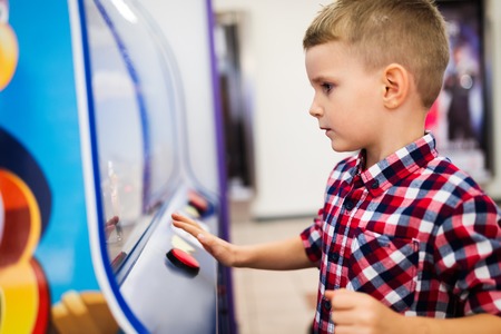 Child playing on the kids game machine