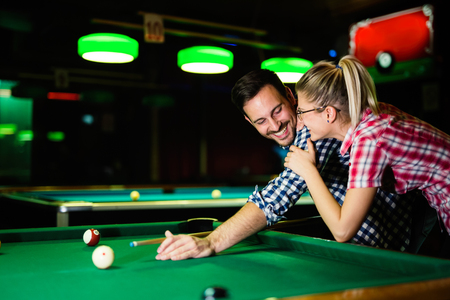 Young couple playing snooker together in barの写真素材
