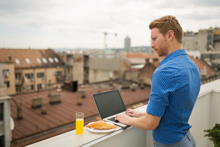 Business person using laptop on rooftopの写真素材