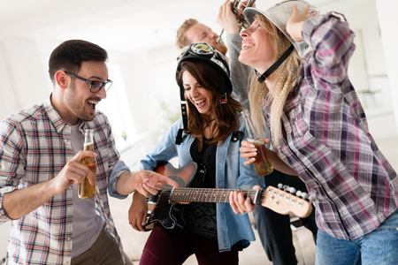 Friends having fun and partying in house and playing musicの写真素材