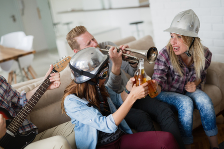 Friends having fun and partying in house and playing musicの写真素材