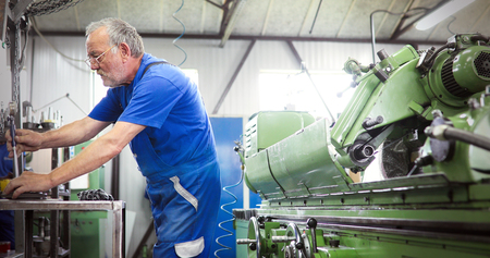 Industrial metal worker working on metal components in factory