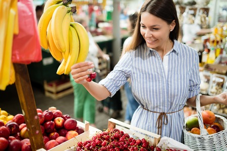 Picture of woman at marketplace buying fruitsの写真素材
