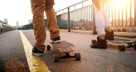 Young attractive couple riding skateboards and having funの写真素材