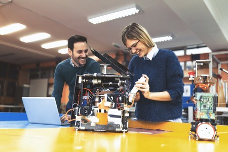 Young attractive students of mechatronics working on project