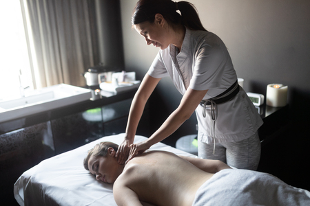 Young woman enjoying massage in spa salonの写真素材