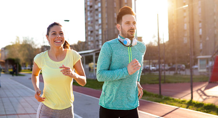 Young fitness couple running in urban area