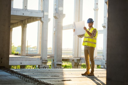 Picture of construction site engineer looking at plan