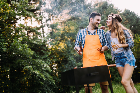 Beautiful woman and handsome man having barbecueの写真素材