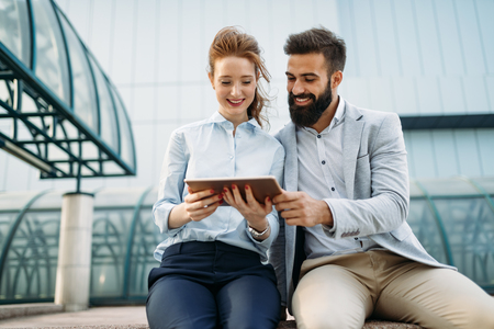Young business couple walking outdoor near office buildingの写真素材