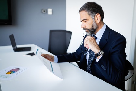Shot of thinking financial advisor businessman working in office.の写真素材