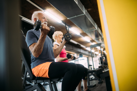 Happy fit mature man in gym working out to stay healthyの写真素材