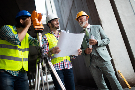 Engineer and construction site manager dealing with blueprints and plansの写真素材